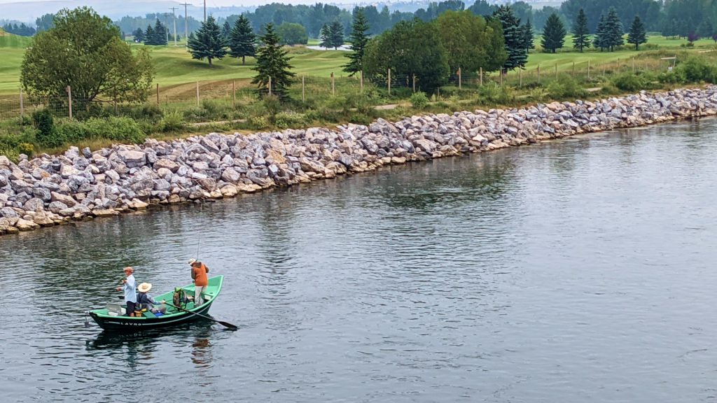 group of people fishing out of a canoe on the bow river