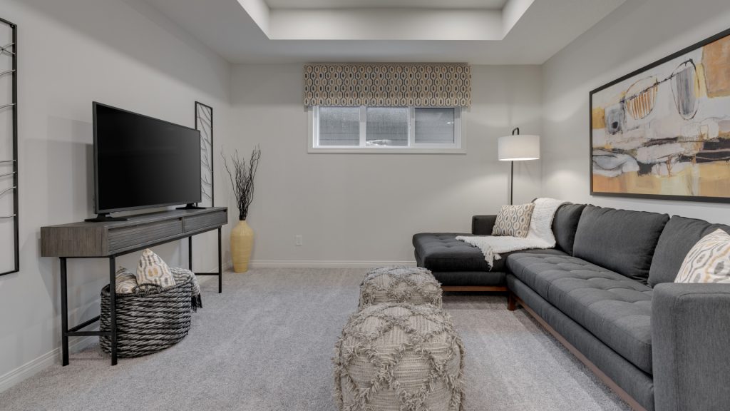 bonus room in the rowan II home with large sofa, chaise lounge, and tv