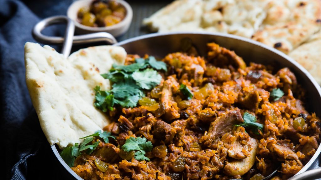 traditional Indian rice dish with nan bread on the side