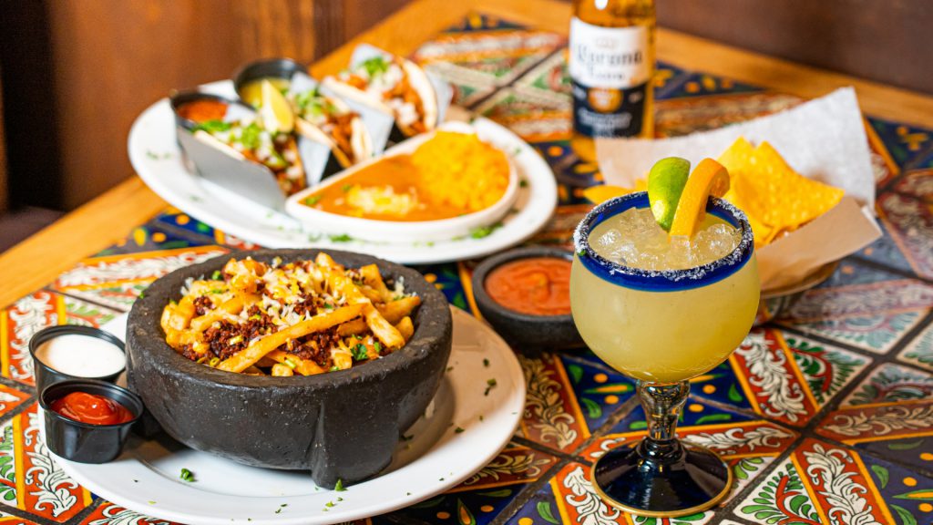 spread of mexican food including tacos, nachos, tortilla soup, and a margarita 