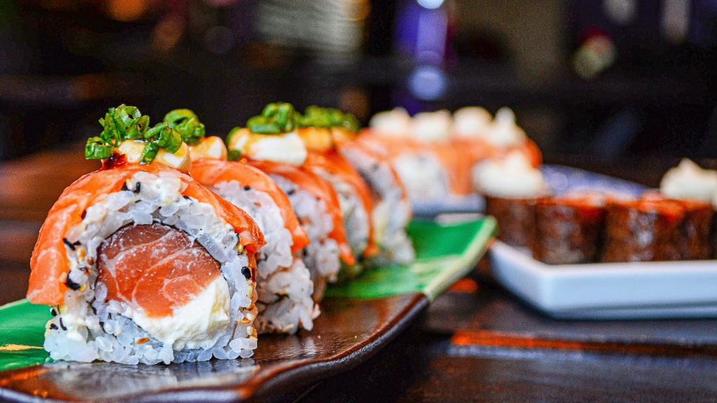 plated roll of sushi with salmon and cream cheese