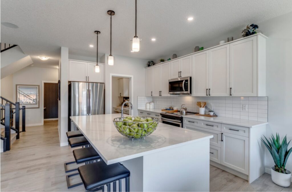 westcreek homes clean white kitchen featuring 
an island with seating and lots of cabinets