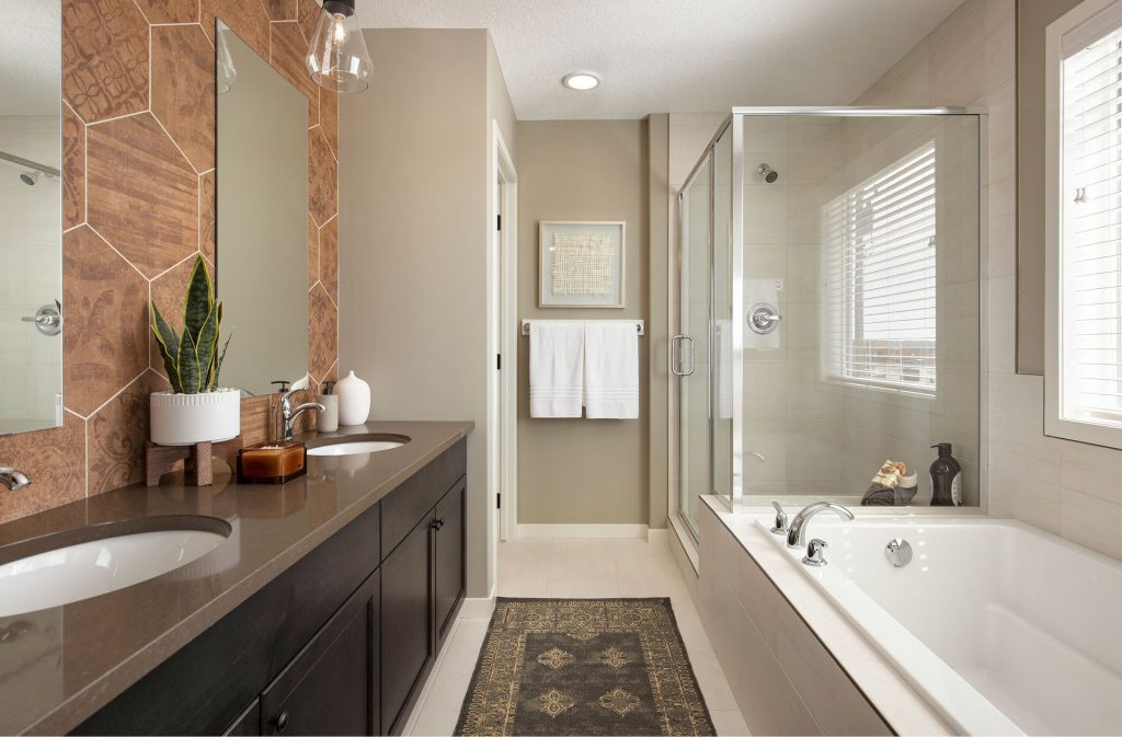 bathroom with soaker tub, glass walled shower, and duel sinks