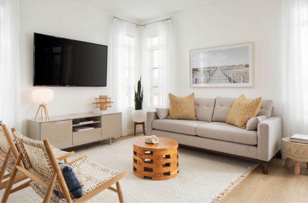 light living room with a large sofa, wall mounted tv, and accent chairs