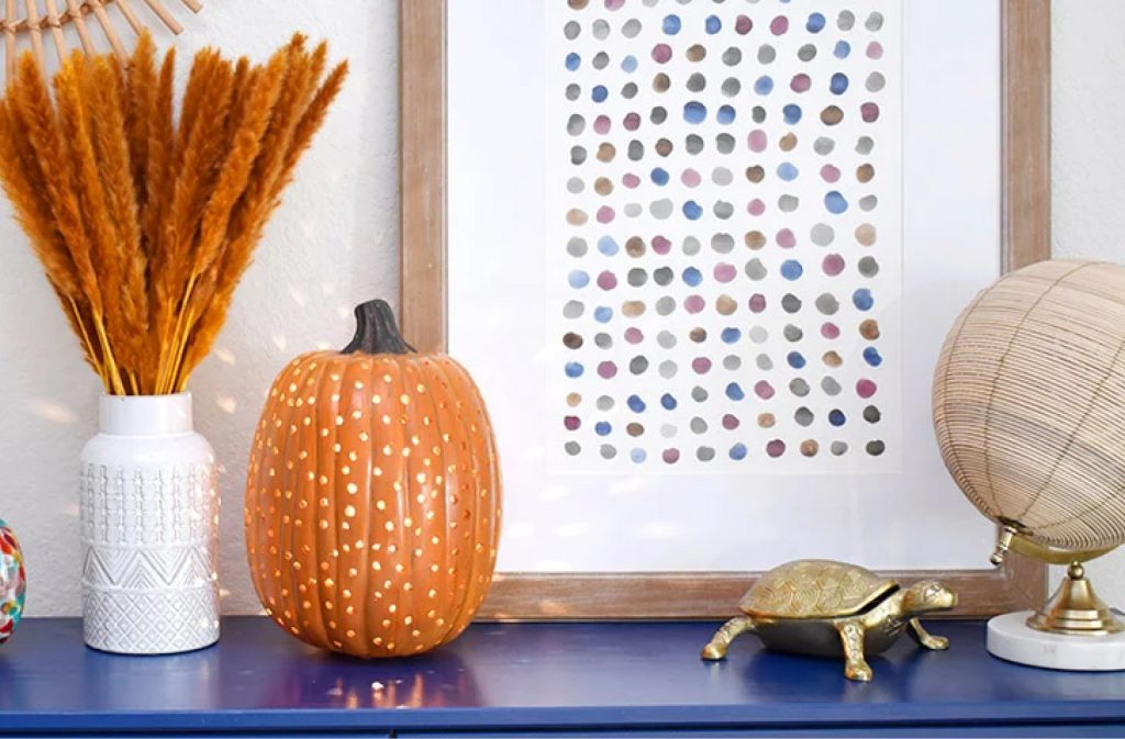 fall and pumpkin themed decor on a blue shelf