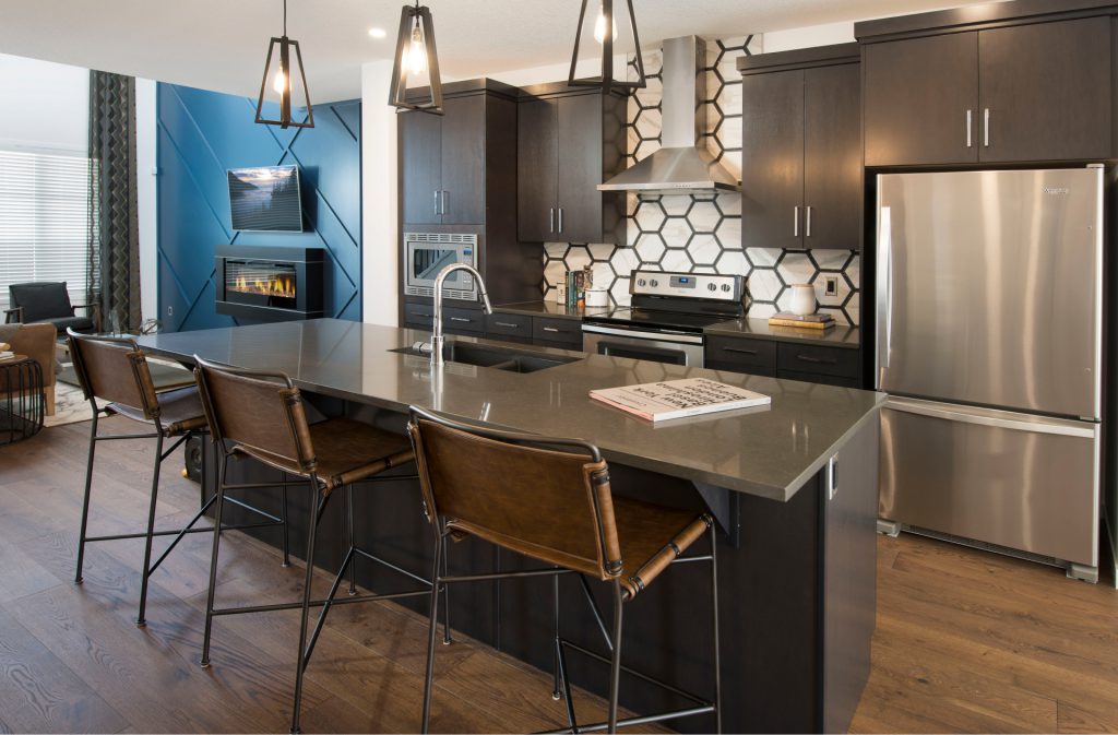 kitchen in the morrison arista home with dark wood, stainless steel appliances, and a blue accent wall