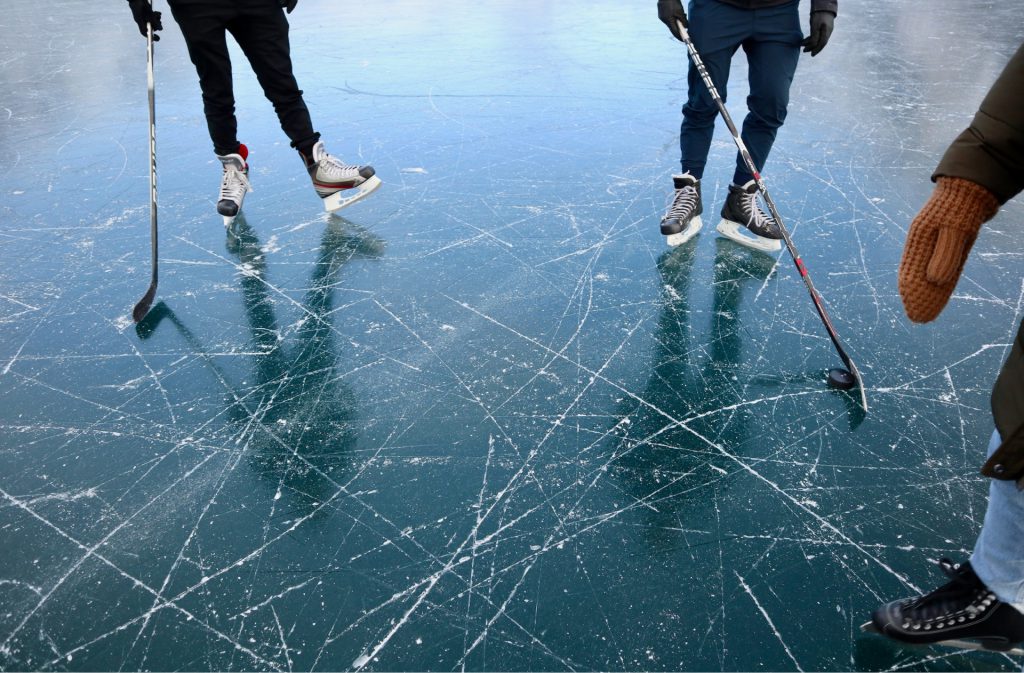 people iceskating with hockey sticks