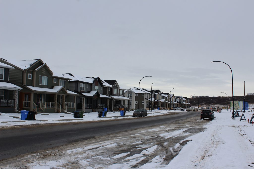 A row of snow-covered houses on a street